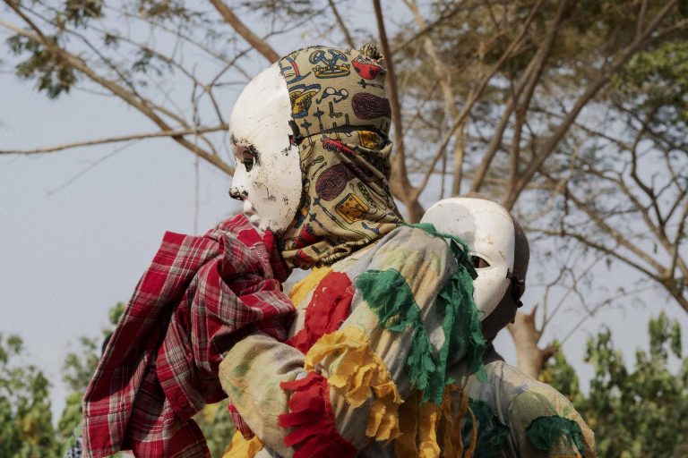 Due maschere tradizionali del Festival del Voodoo durante la sfilata tra le strade di Ouidah. Ouidah, Repubblica del Benin, 2018.